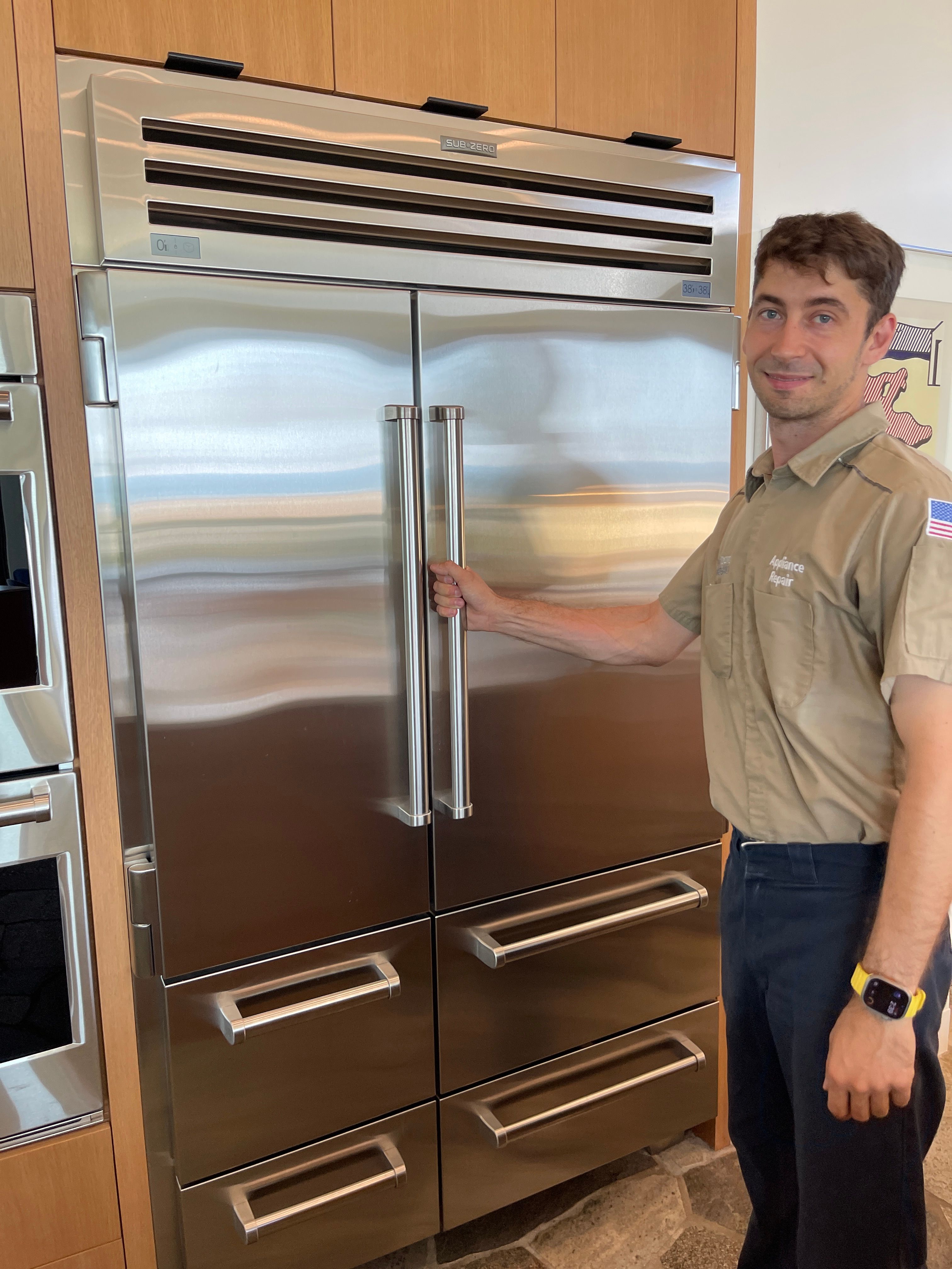 Esquire Appliance Repair technician opening a built-in Sub-Zero PRO 48 refrigerator in an Orange County kitchen